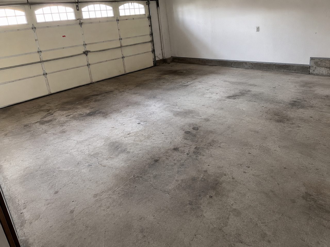Worn bare concrete garage floor before coating in Daytona Beach