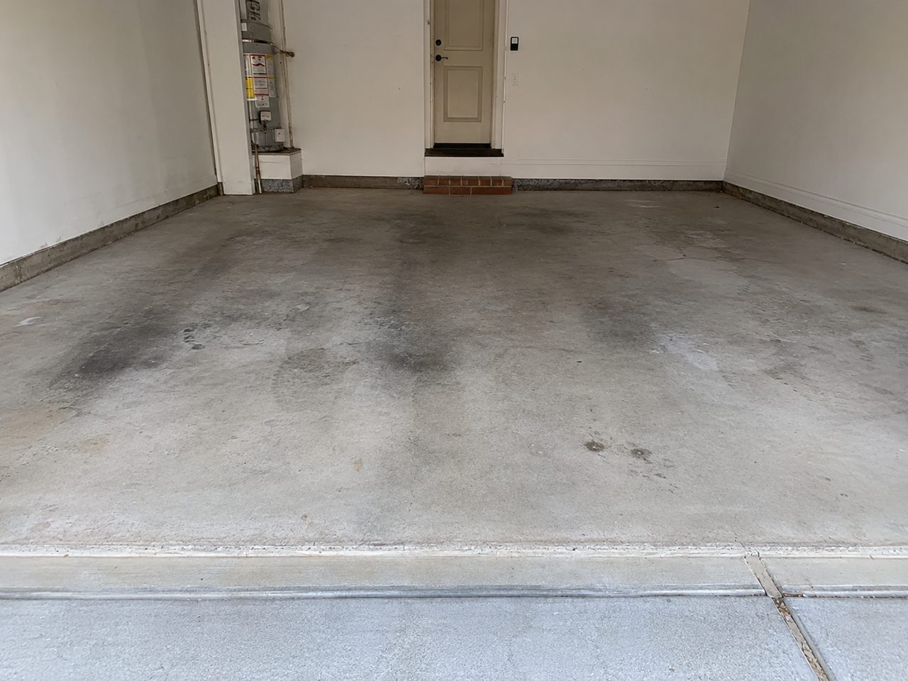 Stained cracked bare concrete garage floor before coating in Daytona Beach